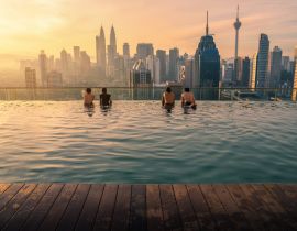 Lais Puzzle - Reisende mit Blick auf die Skyline von Kuala Lumpur im Swimmingpool auf dem Dach eines Hotels bei Sonnenaufgang in Kuala Lumpur, Malaysia - 40, 100, 200, 500, 1.000 & 2.000 Teile