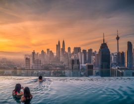 Lais Puzzle - Reisende mit Blick auf die Skyline von Kuala Lumpur im Swimmingpool auf dem Dach eines Hotels bei Sonnenaufgang in Kuala Lumpur, Malaysia - 40, 100, 200, 500, 1.000 & 2.000 Teile