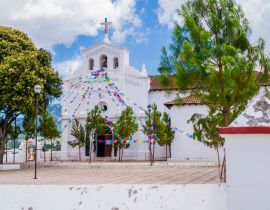 Lais Puzzle - Beeindruckender Blick auf die Kirche San Lorenzo und ihre Vorhalle mit bunten Gebetsfahnen, Zinacantan, Chiapas, Mexiko - 40, 100, 200, 500, 1.000 & 2.000 Teile