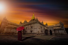 Lais Puzzle - Asiatischer junger Mönch mit rotem Schirm am Ananda-Tempel bei Sonnenuntergang in Bagan, Myanmar - 2.000 Teile