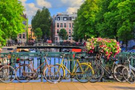 Lais Puzzle - Wunderschöne farbenfrohe Sommerblumen und Fahrräder auf einer Brücke an den berühmten Grachten des Weltkulturerbes in Amsterdam, Niederlande - 2.000 Teile