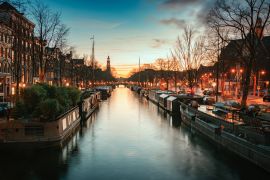Lais Puzzle - Hausboote in der Prinsengracht im alten Zentrum von Amsterdam mit der Turmspitze des Westertoren im Hintergrund bei Sonnenuntergang - 2.000 Teile