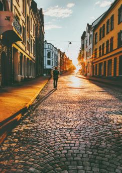 Lais Puzzle - Mann Tourist zu Fuß in Sonnenuntergang Straße Travel Lifestyle Konzept Urlaub Kopfsteinpflaster Straße Alesund Stadt in Norwegen - 1.000 Teile