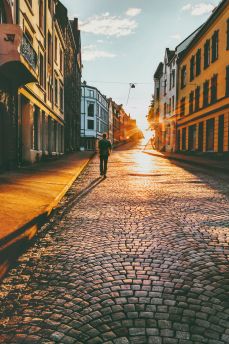 Lais Puzzle - Mann Tourist zu Fuß in Sonnenuntergang Straße Travel Lifestyle Konzept Urlaub Kopfsteinpflaster Straße Alesund Stadt in Norwegen - 2.000 Teile