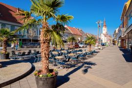 Lais Puzzle - Hauptplatz mit Palmen am Straßencafé und der katholischen Kirche St. Jakobus in der Stadt Leibnitz in der Steiermark in Österreich. Architektur des Doms - 2.000 Teile