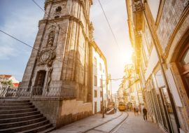 Lais Puzzle - Straßenansicht mit dem Turm der Klerikerkirche mit einer Straßenbahn im Retro-Stil während des Sonnenaufgangs in der Stadt Porto, Portugal - 1.000 Teile