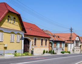 Lais Puzzle - Bunte alte Häuser in der Nähe der befestigten Kirche im Dorf Axente Sever im Kreis Sibiu (Hermannstadt) in der Region Siebenbürgen (Transilvania) in Rumänien an einem sonnigen Sommertag - 40, 100, 200, 500, 1.000 & 2.000 Teile