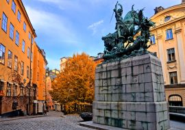 Lais Puzzle - Die Statue des Heiligen Georg und des Drachen und die farbenfrohe Straße im Herbst in Gamla Stan, der Altstadt von Stockholm, Schweden - 1.000 Teile