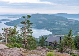Lais Puzzle - Öffentliches Touristenrasthaus vor Blick auf skandinavische Berge mit Kiefernwald, das Dorf und zwei Meeresbuchten, Sommertag mit schweren dramatischen Wolken, Nordschweden - 1.000 Teile
