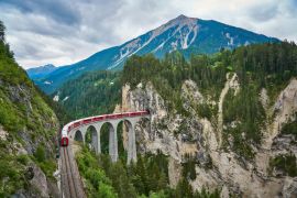 Lais Puzzle - Der rote Zug fährt über die Brücke des Landwasserviadukts im Kanton Graubünden, Schweiz. Der Bernina Express / Glacier Express benutzt diese Bahnstrecke - 2.000 Teile