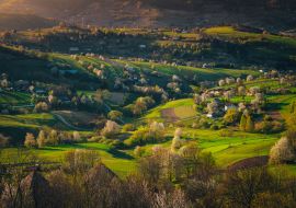 Lais Puzzle - Frühlingssonnenaufgang in einer ländlichen Landschaft mit blühenden Kirschen, hellgrünen Feldern und kleinen Häusern. Die ersten Strahlen der Sonne im Dorf Hrinova in der Slowakei - 1.000 Teile