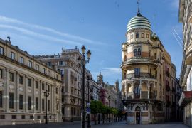 Lais Puzzle - Die 'Avenida de la Constitucion' in Sevilla kurz nach Sonnenaufgang, mit dem schönen 'Confiteria Filella' Turm, der 'Banco de España' und der Kathedrale - 2.000 Teile