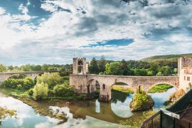 Lais Puzzle - Besalu, Girona, Katalonien, Spanien. Berühmtes Wahrzeichen, die mittelalterliche romanische Brücke von Besalu über den Fluss Fluvia an einem bewölkten Sommertag - 2.000 Teile