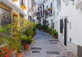 Lais Puzzle - Typische enge Straße mit Blumentopf in Marbella, Costa del Sol, Provinz Malaga. Leere andalusische Straße - 1.000 Teile