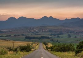 Lais Puzzle - Eine Straße, die bei Sonnenaufgang in der Nähe von Clarens, Südafrika, zu den Drakensbergen führt - 1.000 Teile