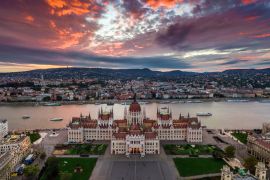 Lais Puzzle - Budapest, Ungarn - Panoramablick auf das Parlament von Ungarn bei Sonnenuntergang mit schönen dramatischen lila Wolken und Ausflugsbooten auf der Donau - 2.000 Teile