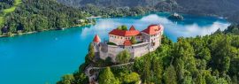 Lais Puzzle - Bled, Slowenien - Panoramablick aus der Luft auf die wunderschöne Burg Bled (Blejski Grad) mit dem Bleder See (Blejsko Jezero), der Kirche Maria Himmelfahrt und den Julischen Alpen im Hintergrund an einem Sommertag, Panorama - 1.000 Teile