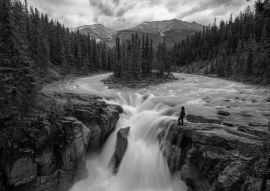 Lais Puzzle - Frau steht am Rande einer Klippe an einem wunderschönen Wasserfall in den kanadischen Rockies während eines Sommertages. Aufgenommen in Sunwapta Falls, Jasper, Alberta, Kanada in schwarz weiß - 500, 1.000 & 2.000 Teile