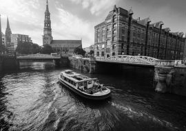 Lais Puzzle - Touristisches Kreuzfahrtschiff auf einem Kanal mit Brücken in der alten Speicherstadt in Hamburg im goldenen Licht des Sonnenuntergangs, Deutschland in schwarz weiß - 1.000 Teile
