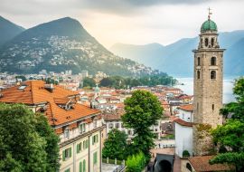 Lais Puzzle - Stadtbild von Lugano mit Glockenturm der Kathedrale St. Lorenz und Blick auf den See und dramatisches Licht in Lugano Schweiz - 1.000 Teile