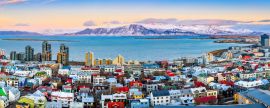 Lais Puzzle - Luftbildpanorama der Innenstadt von Reykjavik bei Sonnenuntergang mit bunten Häusern und verschneiten Bergen im Hintergrund - 2.000 Teile