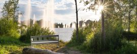 Lais Puzzle - Ainolan puisto Stadtpark in Oulu, Finnland. Springbrunnen in der Sonne und Wohnhäuser im Hintergrund - 2.000 Teile