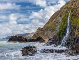 Lais Puzzle - Ein Wasserfall an der walisischen Küste in dem kleinen Fischerdorf Tresaith. Das Meer ist wild, ebenso wie der weiß-blaue Wolkenhimmel. Im Hintergrund die hohen Klippen - 1.000 Teile