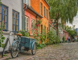 Lais Puzzle - An einem Sommertag parkt ein typisch dänisches Cargo-Bike, besser bekannt als Christiania Bike, am Eingang eines Hauses in einer gemütlichen, gepflasterten Straße, die Gemütlichkeit und ein kulturelles Konzept vermittelt - Aarhus, D...
