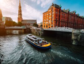 Lais Puzzle - Touristisches Kreuzfahrtschiff auf einem Kanal mit Brücken in der alten Speicherstadt in Hamburg im goldenen Licht des Sonnenuntergangs, Deutschland - 1.000 Teile