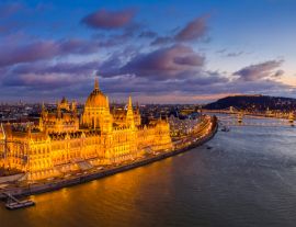 Lais Puzzle - Budapest, Ungarn - Panoramablick aus der Luft auf das beleuchtete ungarische Parlament mit der Szechenyi Kettenbrücke, dem Königlichen Schloss Buda und bunten Wolken im Hintergrund bei Sonnenuntergang - 1.000 Teile