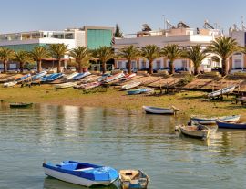 Lais Puzzle - Blick auf die Küste von Isla Cristina, mit bunten Booten und Palmen am Ufer - 1.000 Teile